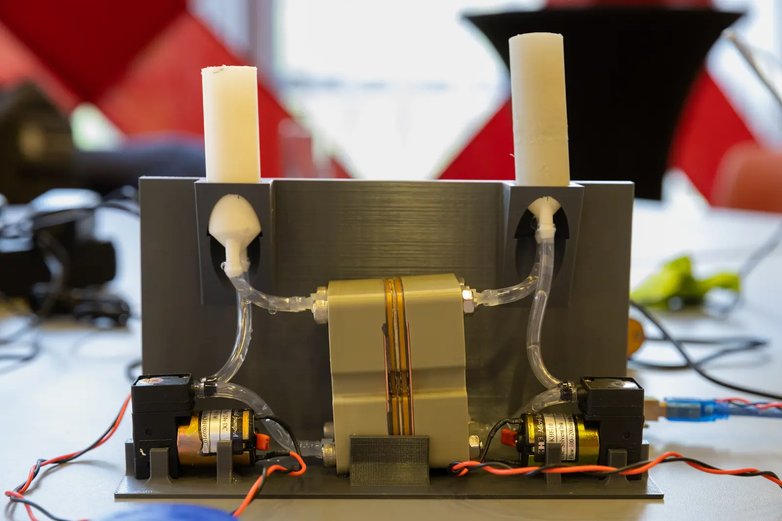 A flow cell with tubing connected sitting in a jig with pumps and reservoirs